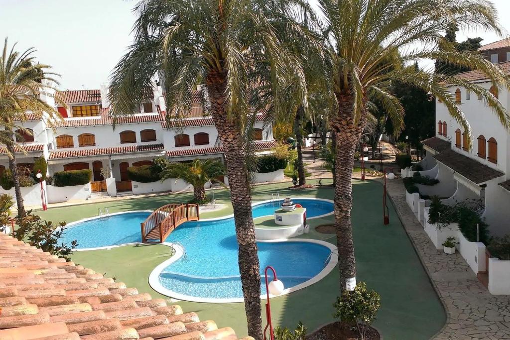 un complexe avec une piscine et des palmiers dans l'établissement Casa Naiman - Roda de Bara, à Roda de Bará