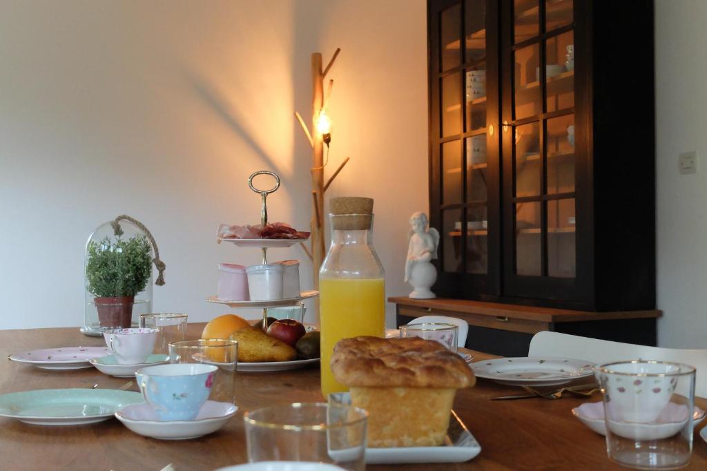 einen Tisch mit einer Flasche Orangensaft und Essen darauf in der Unterkunft La Maison d'Ange in Le Hohwald