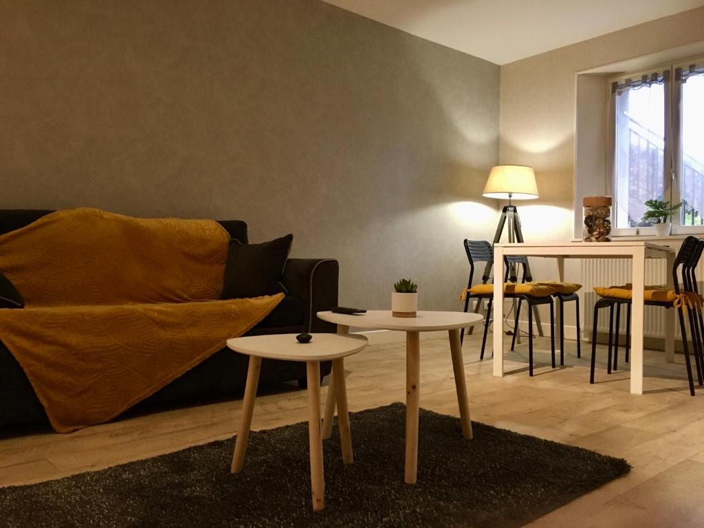 ein Wohnzimmer mit 2 Tischen und einem Sofa in der Unterkunft Appartement Guéret in Guéret
