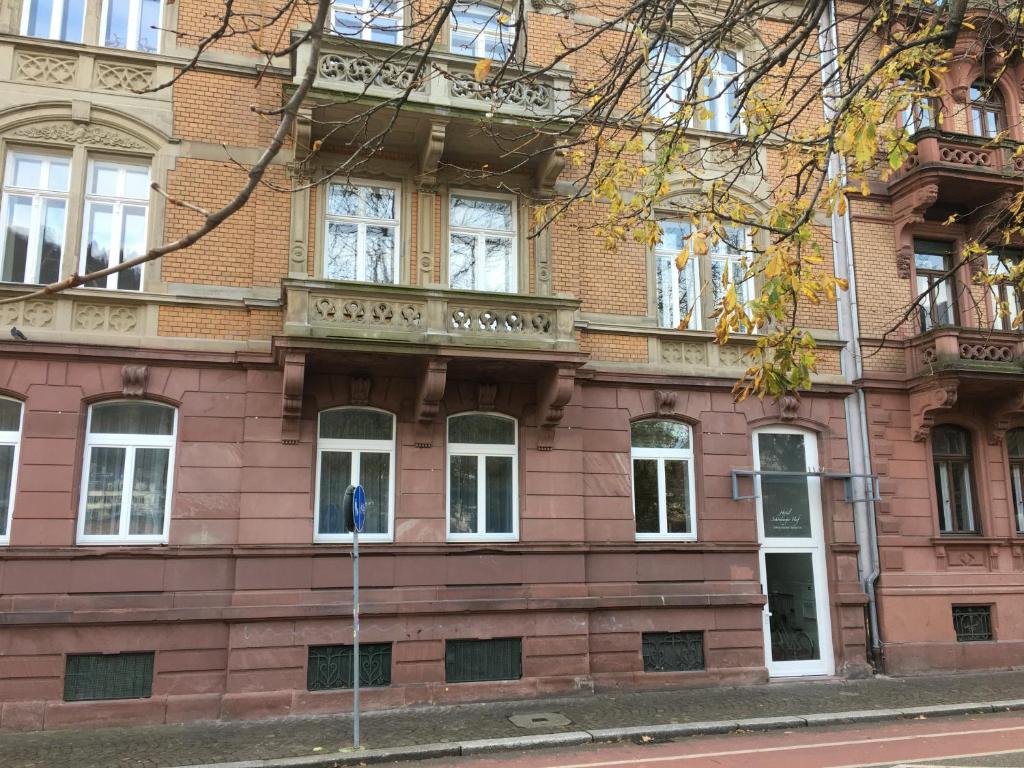un edificio de ladrillo rojo con ventanas blancas en una calle en Perkeo Apartments, en Heidelberg