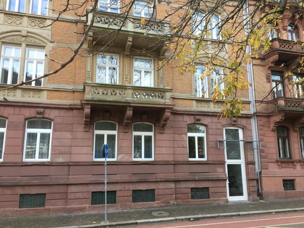 een rood bakstenen gebouw met witte ramen op een straat bij Perkeo Apartments in Heidelberg