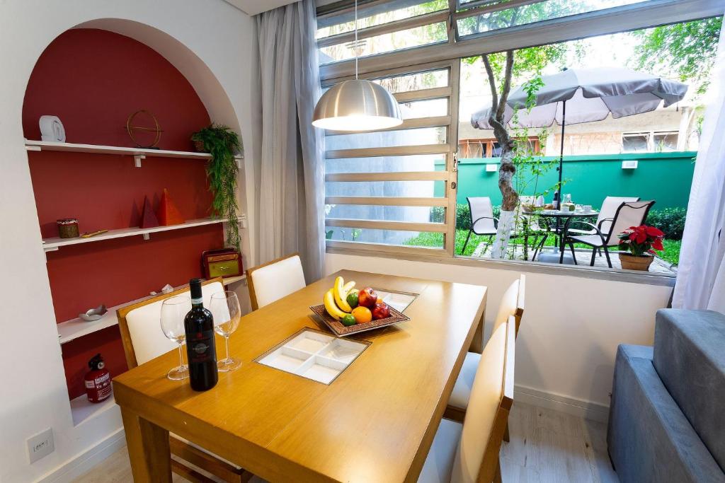 Apartamento com quintal em Alto de Pinheiros في ساو باولو: غرفة طعام مع طاولة مع وعاء من الفواكه عليها