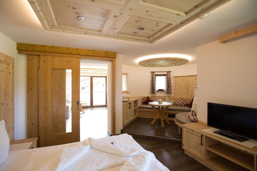 ein Schlafzimmer mit einem Bett und einem TV sowie ein Badezimmer in der Unterkunft Landhaus Schnöller in Tannheim