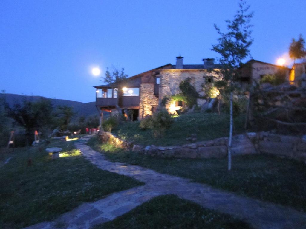 une maison en pierre la nuit avec la lune dans le ciel dans l'établissement Louteiro de las Médulas, à Orellán