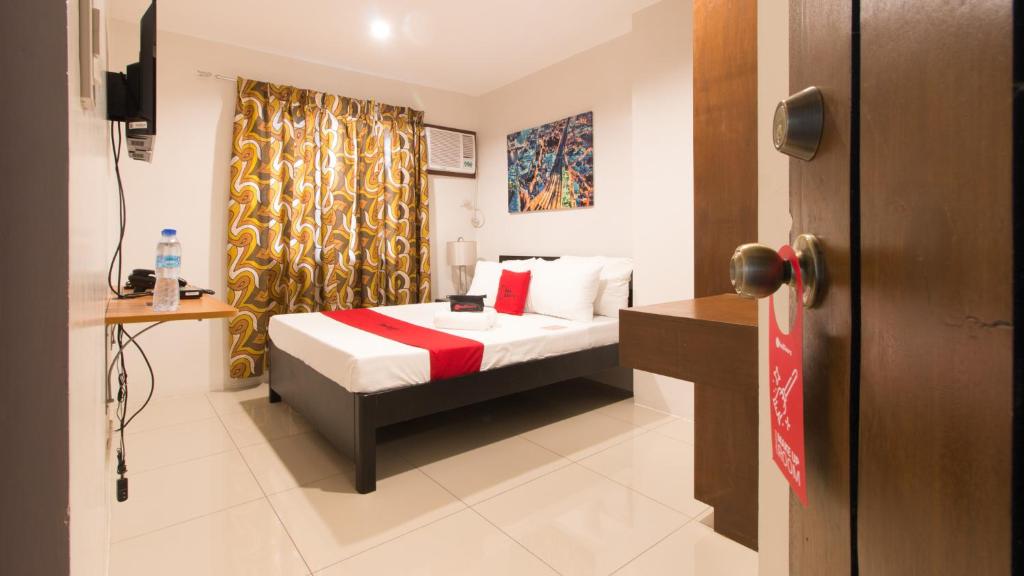 a hotel room with a bed and a window at RedDoorz Plus @ Diola Villamonte Bacolod in Bacolod