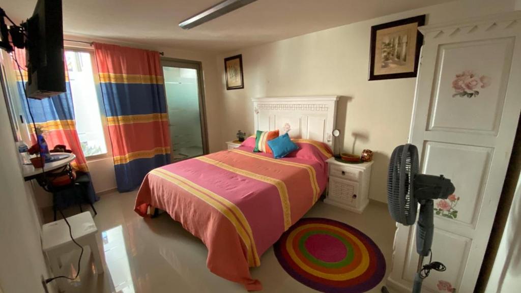 1 dormitorio con 1 cama con colcha colorida en Casa Ana Celia en Morelia