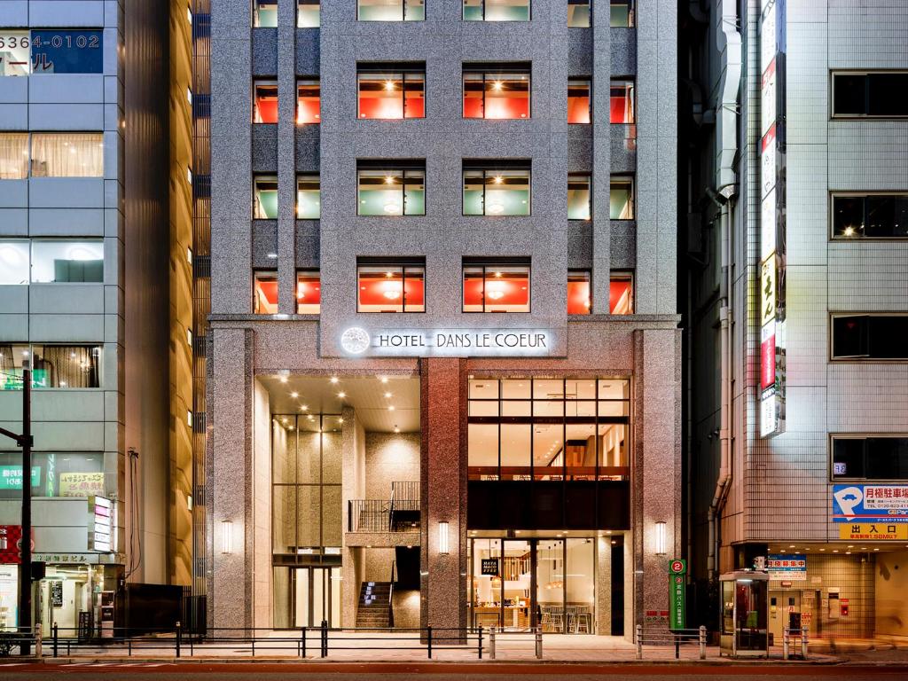 a building with a sign on the front of it at Hotel Dans Le Coeur Osaka Umeda in Osaka