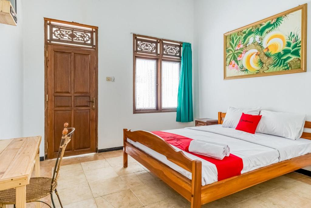 1 dormitorio con cama grande y mesa de madera en RedDoorz Syariah near Gor Ken Arok, en Malang