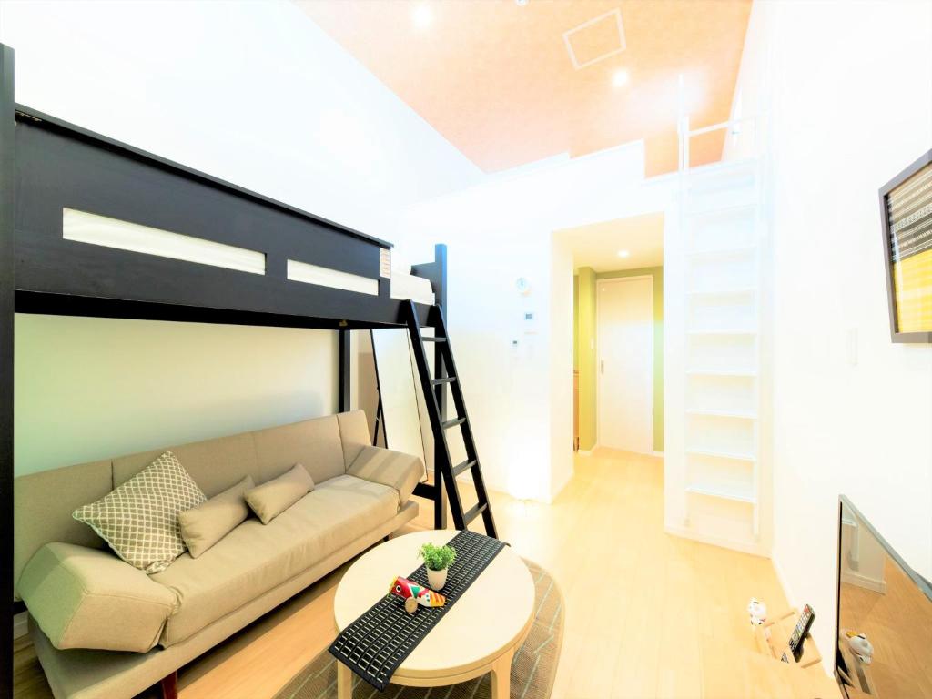 - un salon avec un canapé et une mezzanine dans l'établissement TRIP POD KOMONDO-MACHI, à Fukuoka