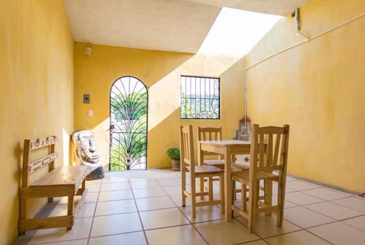 a dining room with a table and chairs and a window at Posada del Rey Azúcar in Salina Cruz