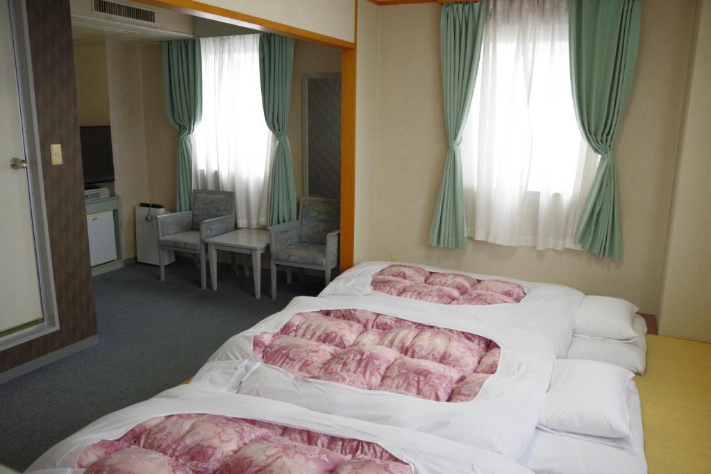 Postel nebo postele na pokoji v ubytování Seagrande Shimizu Station Hotel