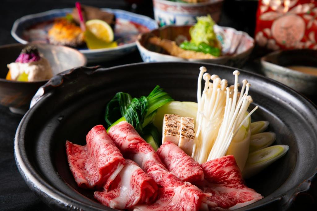 un bol de nourriture avec de la viande et d'autres aliments dans l'établissement Yufuin Kaze no Mori, à Yufu