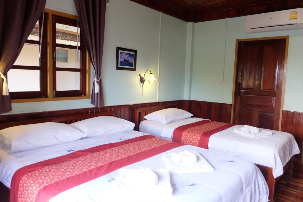 2 camas en una habitación con ventana en Yataa Spa and Resort, en Ko Sukon