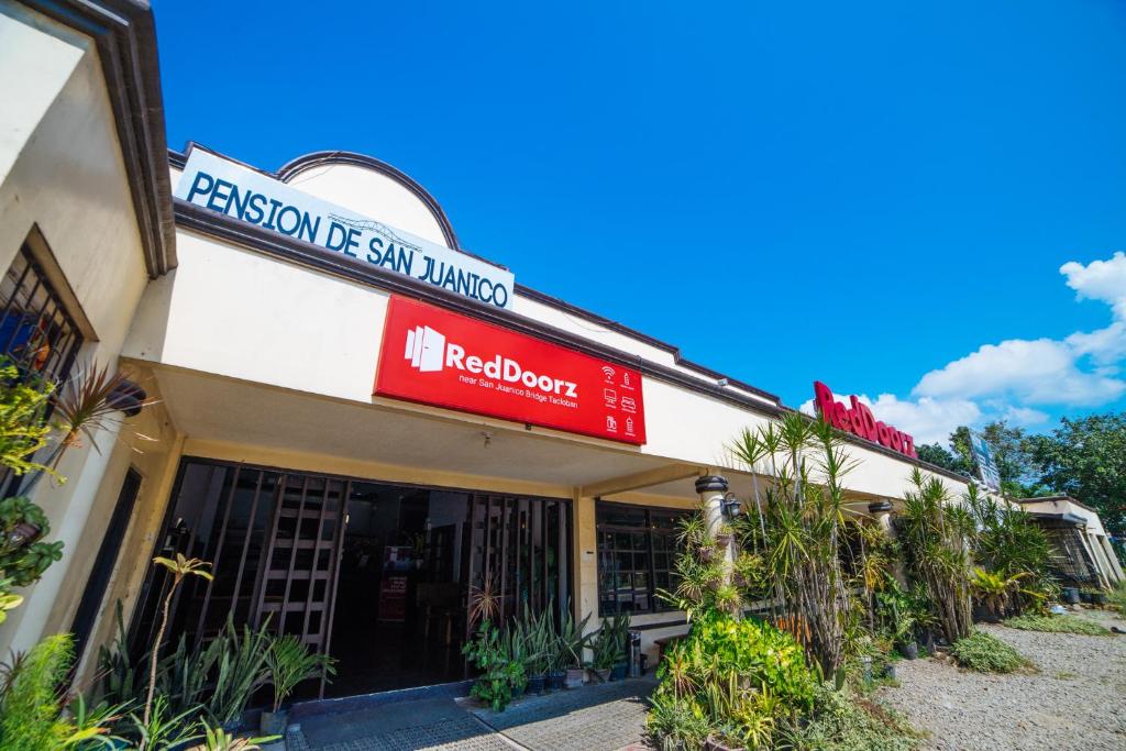 a building with a red sign on the front of it at RedDoorz near San Juanico Bridge in Tacloban