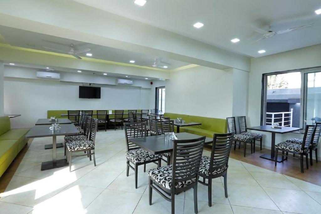 a dining room with tables and chairs and a tv at Dean Villa in Lonavala