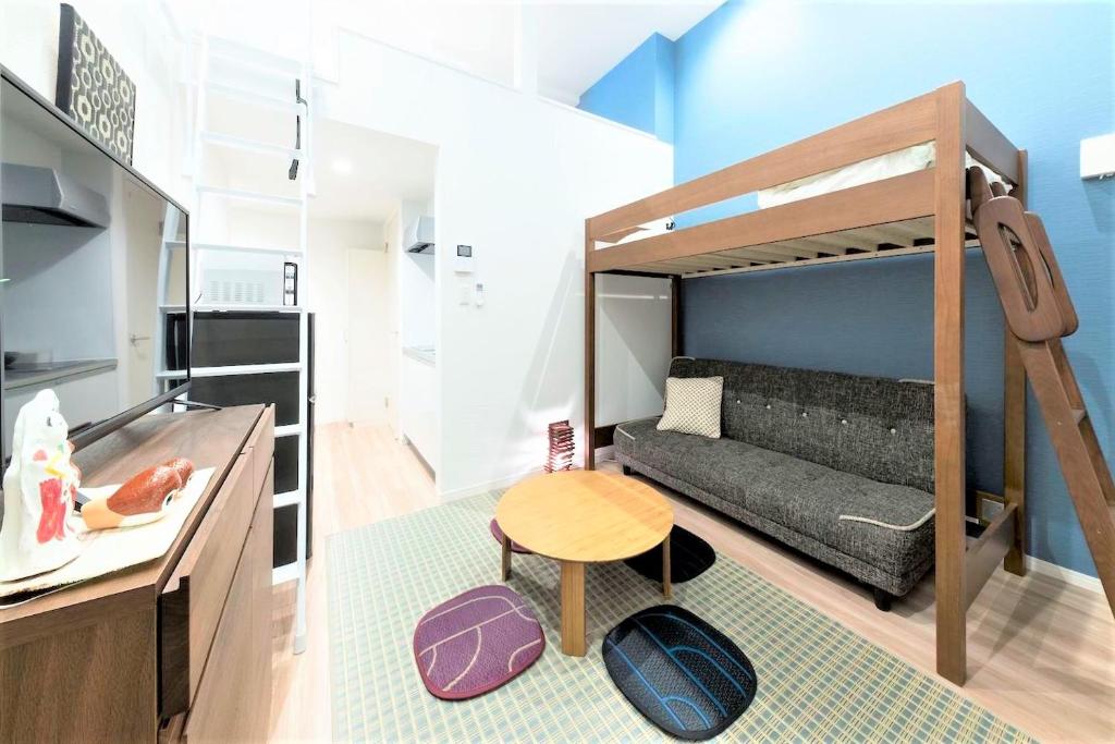 a small room with a bunk bed and a table at TRIP POD SUMIYOSHI C in Fukuoka