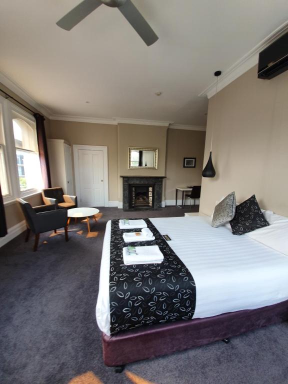 a bedroom with a large bed and a living room at Grand Hotel in Newcastle