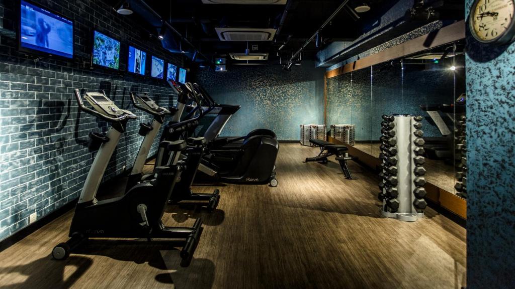 a gym with cardio equipment and a clock on the wall at Hotel G Singapore in Singapore