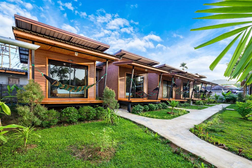 a wooden house with a pathway in front of it at Baan Check In in Ko Lanta