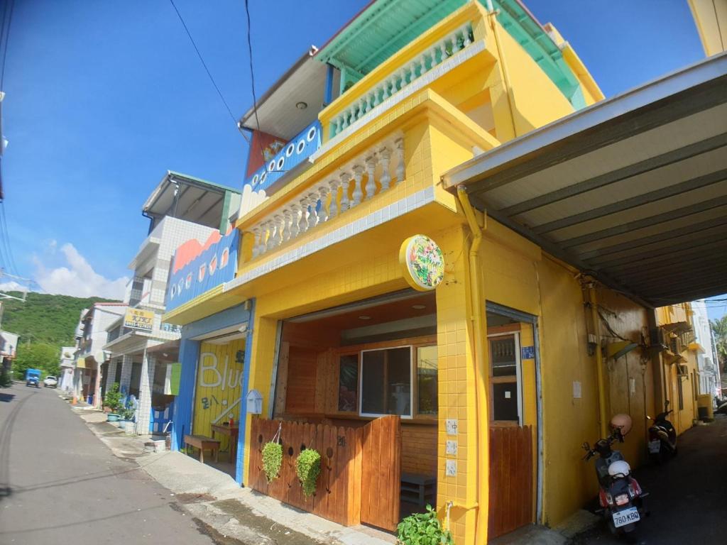 a yellow building on the side of a street at Ola Nanwan Guesthouse in Nanwan