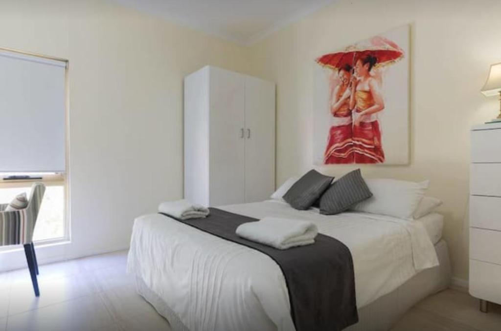 a bedroom with a bed with a painting on the wall at M102 West Perth Studio Apartment near Kings Park in Perth