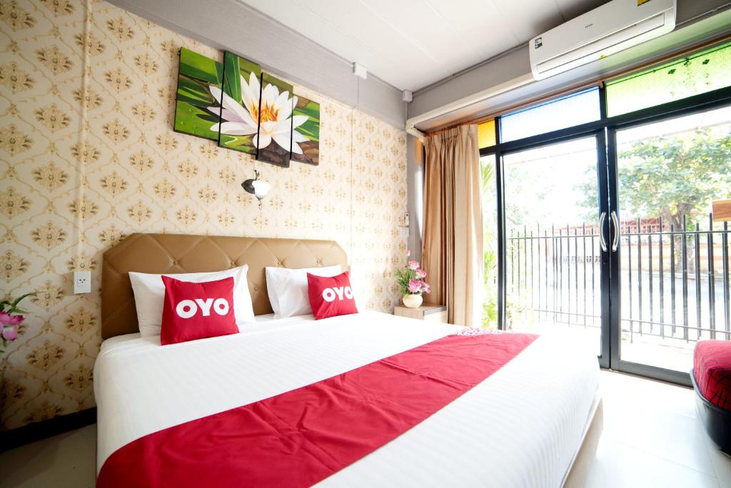 a bedroom with a large bed with red pillows at OYO 465 Krung Kao Traveller Lodge in Phra Nakhon Si Ayutthaya