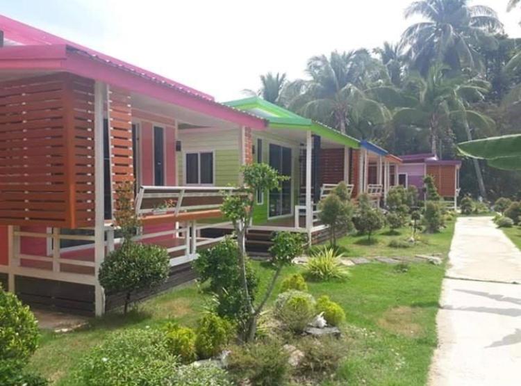 a row of colorful houses in a yard at Phumiphat resort Koh Mook in Trang