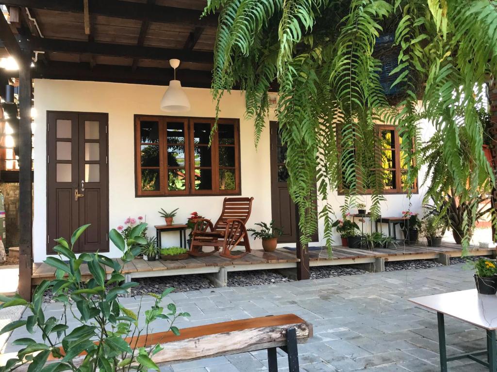 a house with benches and plants in front of it at ครูหนูบ้านพัก แหลมงอบ Krunou baanpak in Trat