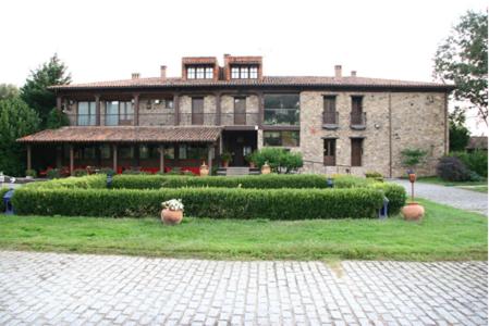 Una casa grande con un jardín enfrente. en Hotel Rural Peña Del Alba en Arroyomolinos de la Vera