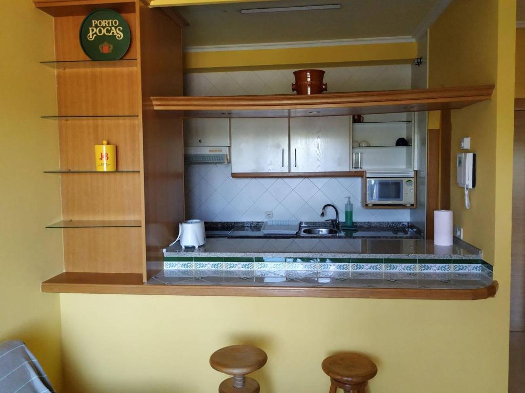 cocina con armarios blancos y encimera en Primera Línea De Playa Avenida De Samil 55, en Vigo