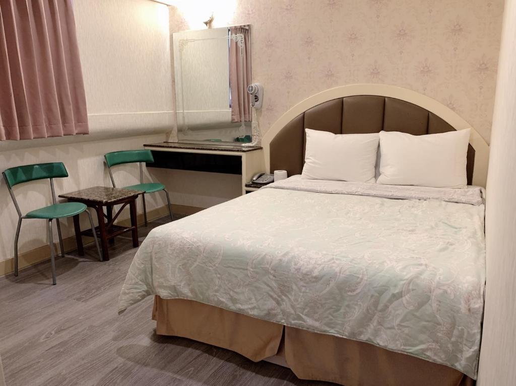a bedroom with a bed and a table and a mirror at Jia Jia Hotel in Yonghe