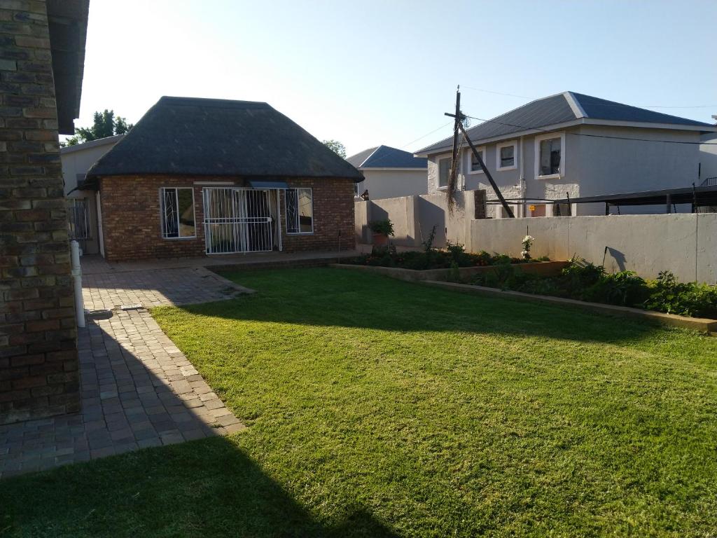 einen Hof mit einem Haus und einem Zaun in der Unterkunft LPM Guest in Pretoria