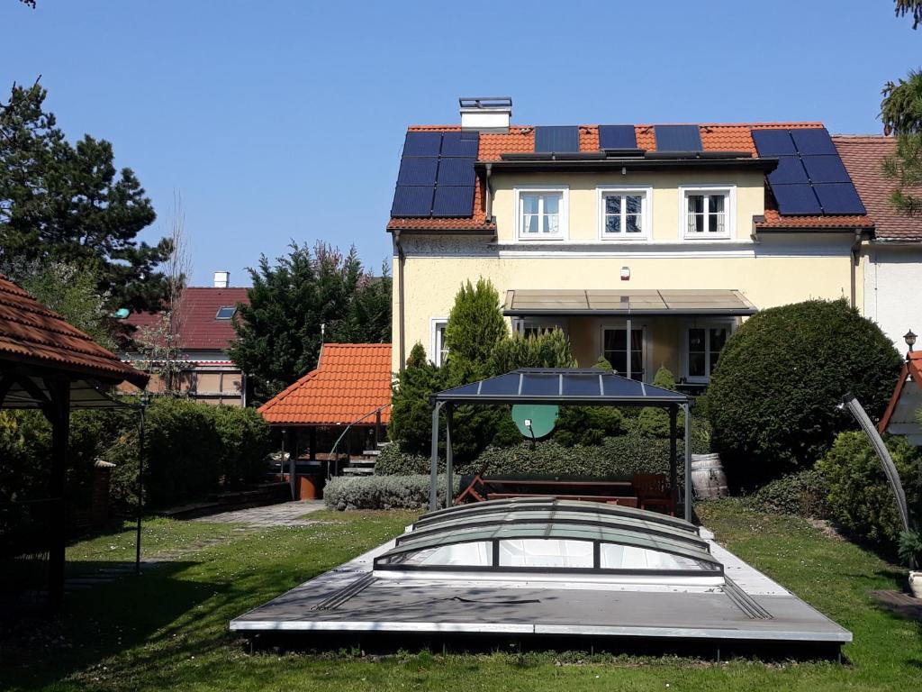 ein Haus mit Sonnenkollektoren auf dem Dach in der Unterkunft Bed & Pool in Wiener Neustadt