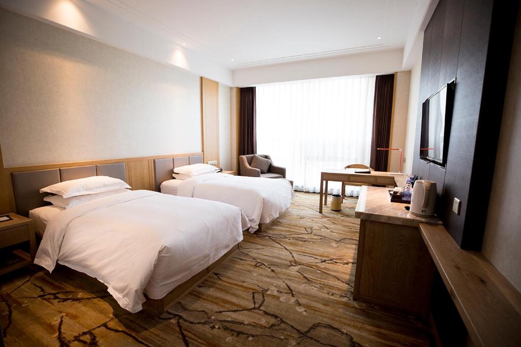 Postel nebo postele na pokoji v ubytování Metropark Hotel Yingkun Beijing