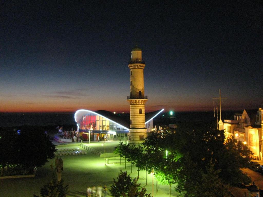 a lit up lighthouse in a city at night at Berringer, Backbord, direkt an der Promenade in Warnemünde
