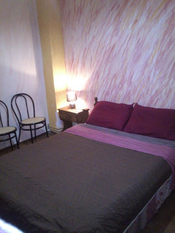 een slaapkamer met een bed en een tafel en stoelen bij Sun Corfu near the airport in Corfu-stad