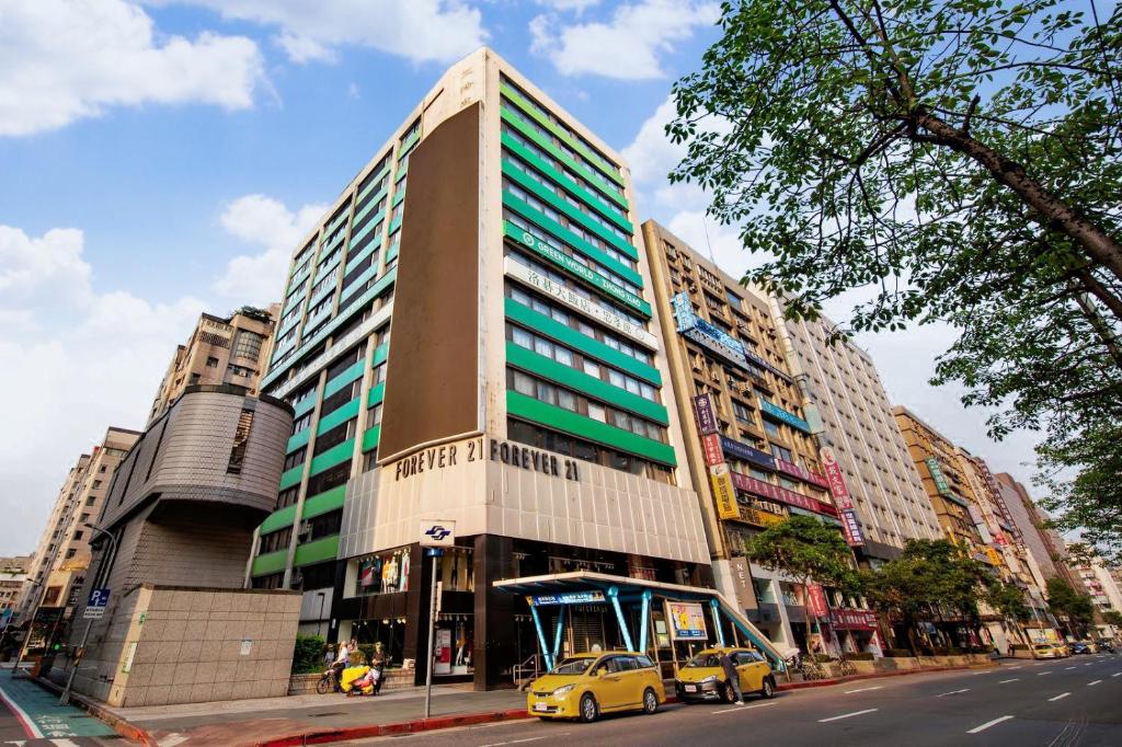 a tall building with cars parked in front of it at Green World ZhongXiao in Taipei