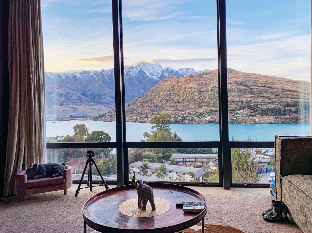 a living room with a cat statue in front of a large window at GoldRush Haven in Queenstown