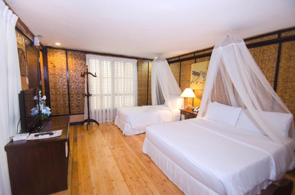 a hotel room with two beds and a television at Sea Wind Resort in Boracay