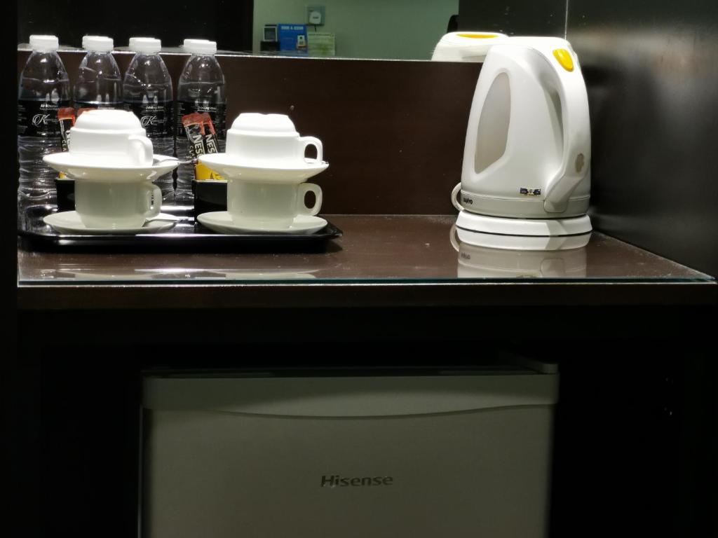 a kitchen counter with two cups and a coffee maker at Kimberley Hotel Georgetown in George Town