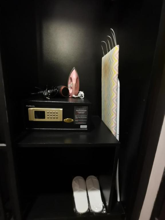 a black shelf with a radio and a box on it at Kimberley Hotel Georgetown in George Town