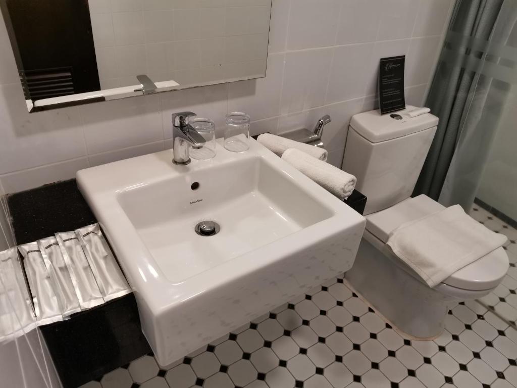 a white bathroom with a sink and a toilet at Kimberley Hotel Georgetown in George Town
