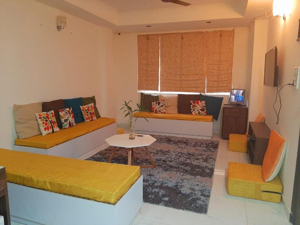 a living room with a couch and a table at Sprinklers in New Delhi