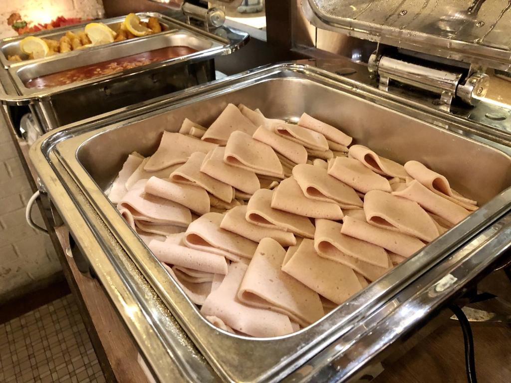 a tray of hot dogs and other food in a kitchen at Kimberley Hotel Georgetown in George Town