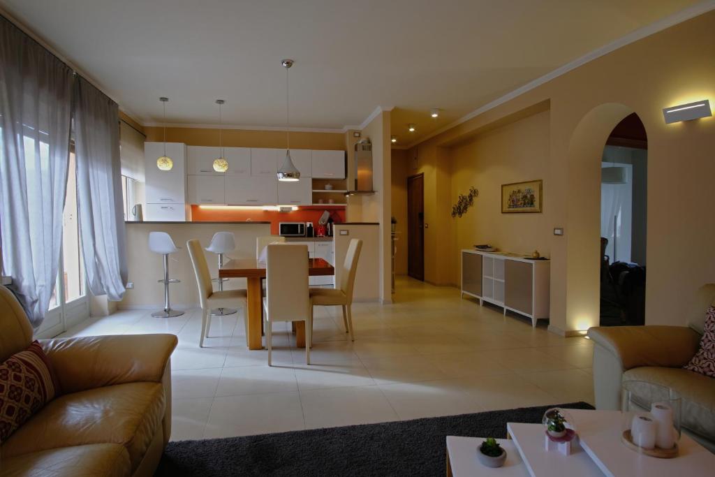 a living room and kitchen with a table and chairs at La maison du boulevard in Aosta