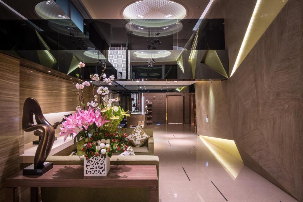 a lobby with flowers on a table and a hallway at Green World JianPei in Taipei