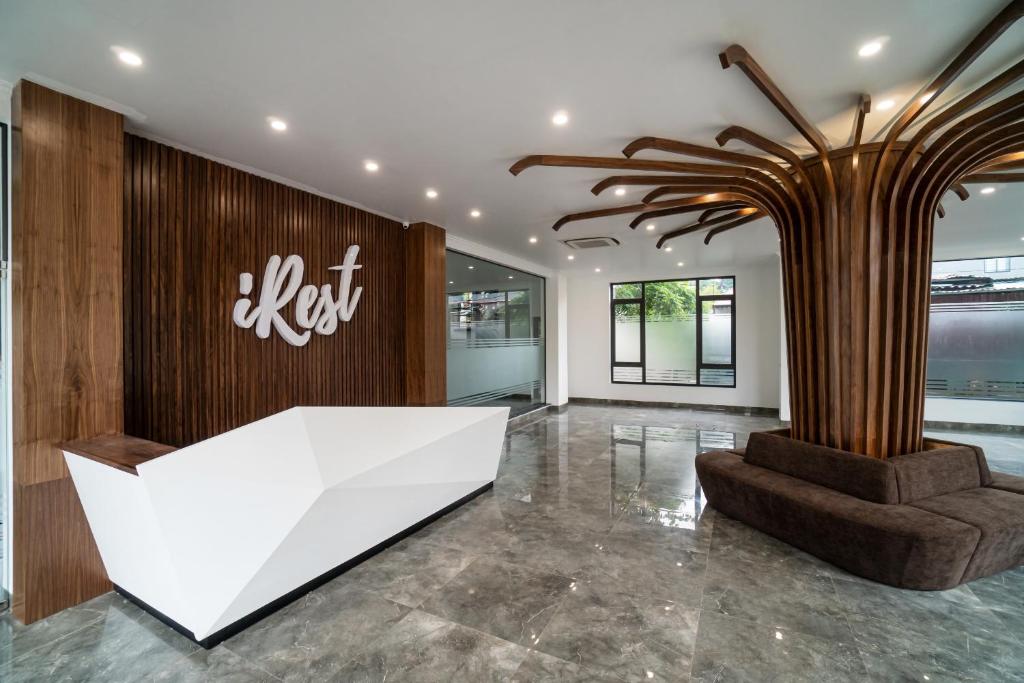 a lobby with a white desk and a palm tree at iRest Apartment Vinh Yen in Yen