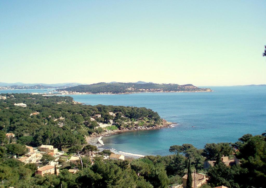 uma vista para uma praia com árvores e o oceano em Villa Fabregas em La Seyne-sur-Mer
