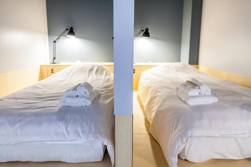 2 imágenes de un dormitorio con toallas en una cama en Area Inn Fushimicho Fukuyama Castle Side 2-8 en Fukuyama