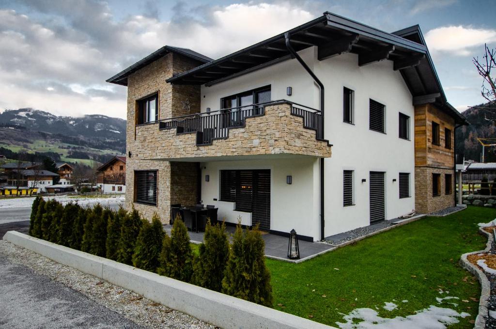 uma casa branca com uma varanda em cima em Kitz Juwel Top 1 em Hollersbach im Pinzgau